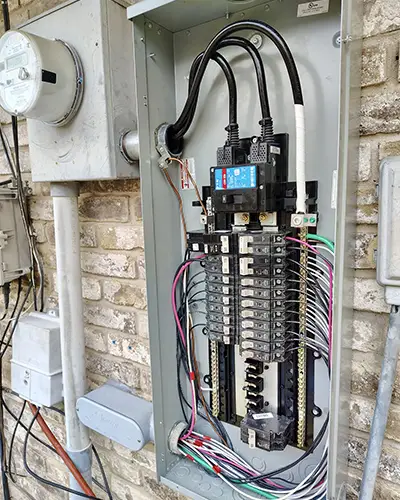 an exposed electrical panel with exposed wires and breakers